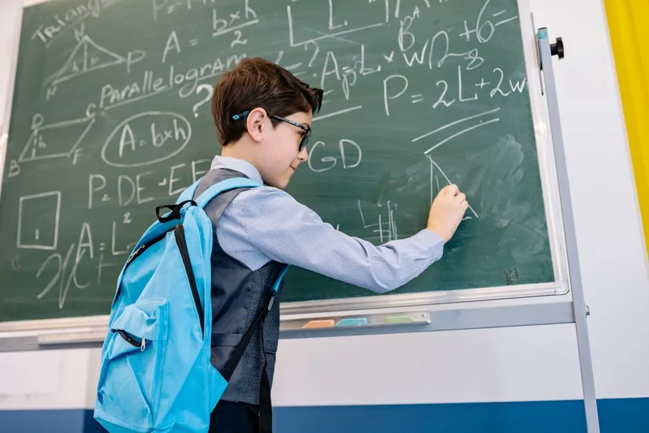 A student working through a math problem on a chalkboard